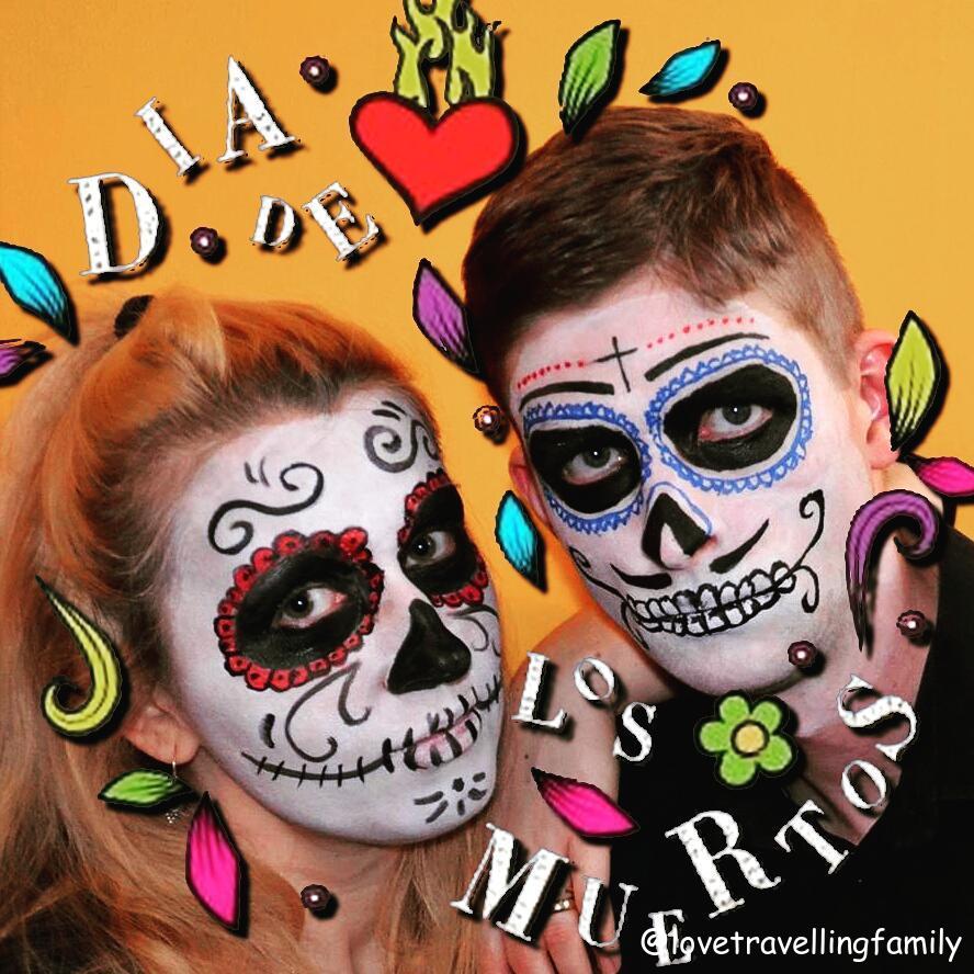 Two parents with sugar-skull face paint in black, red and blue, framed by hand-drawn Día de los Muertos lettering.