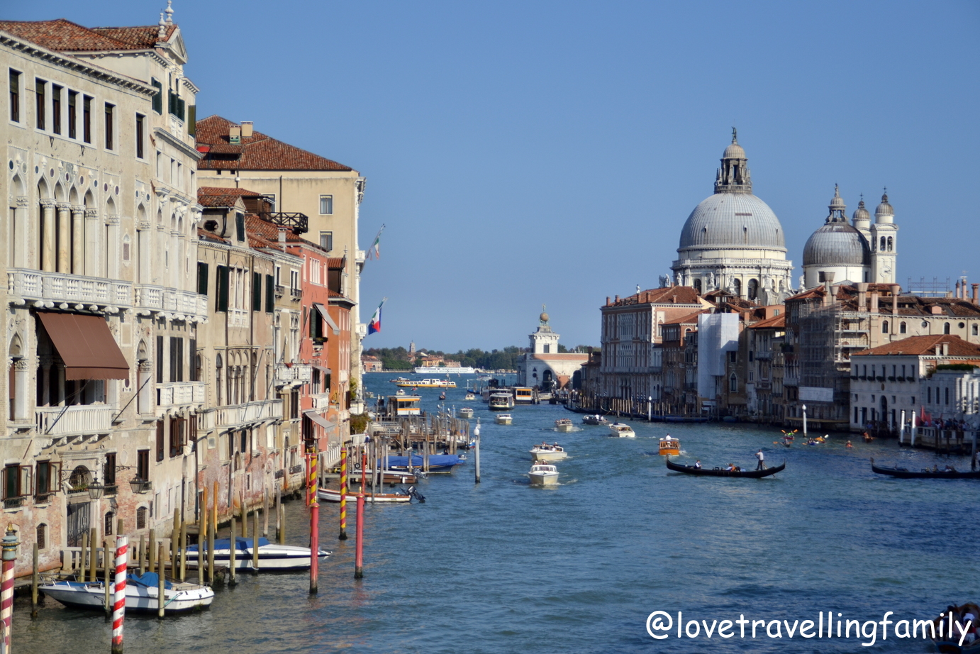 Gondolas and boats on the Grand Canal in Venice with the dome of Santa Maria della Salute.